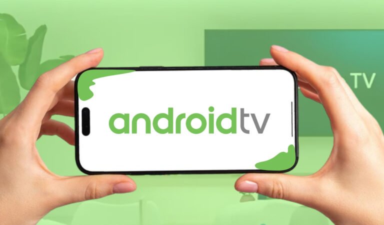 Mão segurando um celular com a tela mostrando o nome Android TV