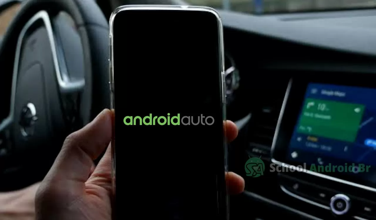 Mão segurando um celular dentro de um carro, com a tela preta exibindo o nome 'Android Auto'.